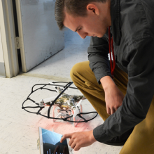 Student working on a tablet and a drone